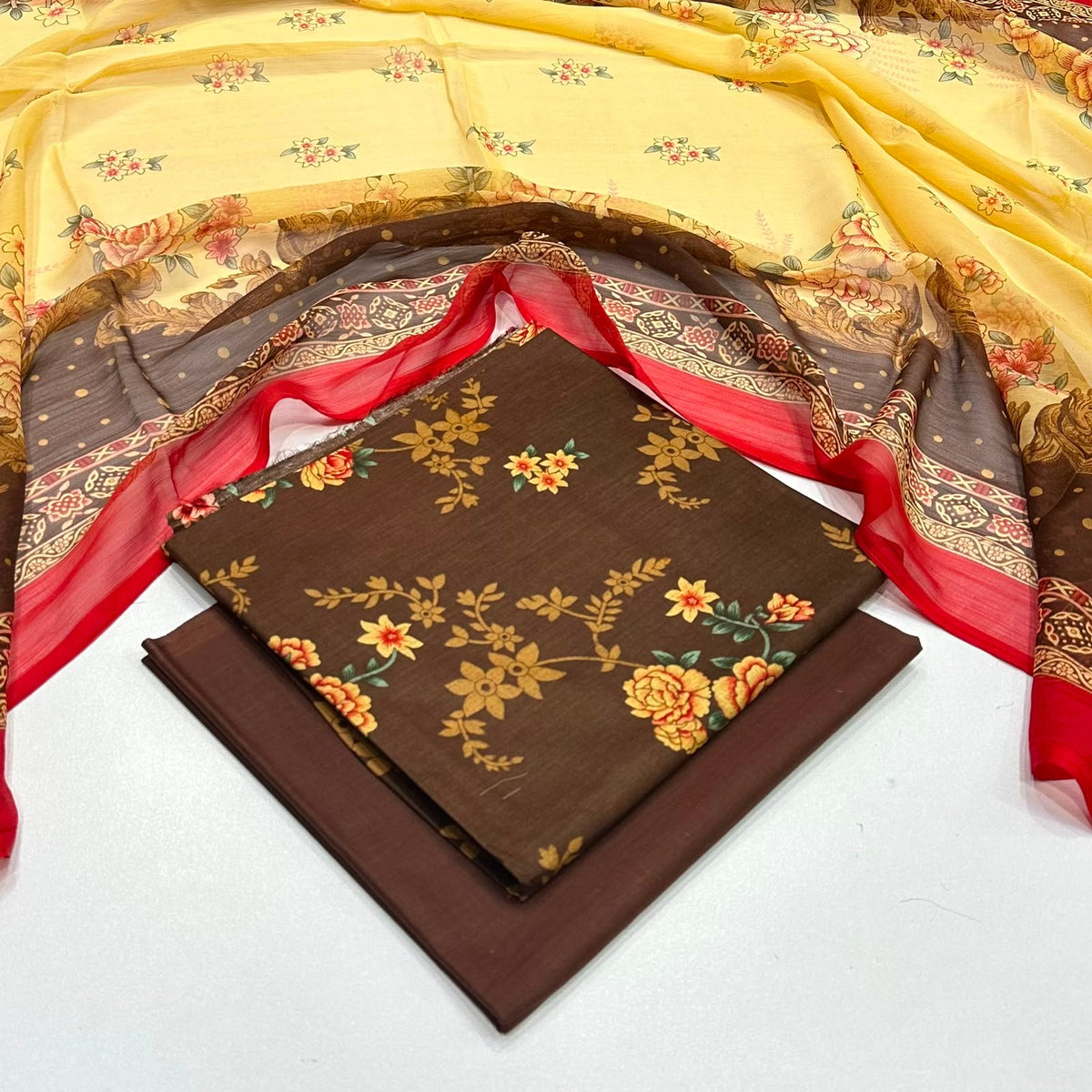 ladies 3 piece suit in brown with a floral print and with a yellow and brown patterned dupatta 