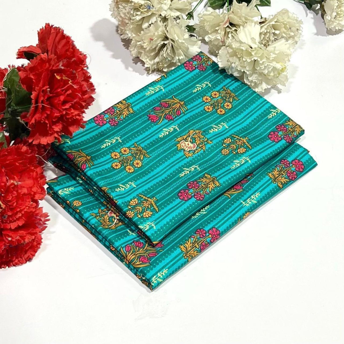 2 piece suit in teal featuring a pattern of gold, pink, and red floral motifs