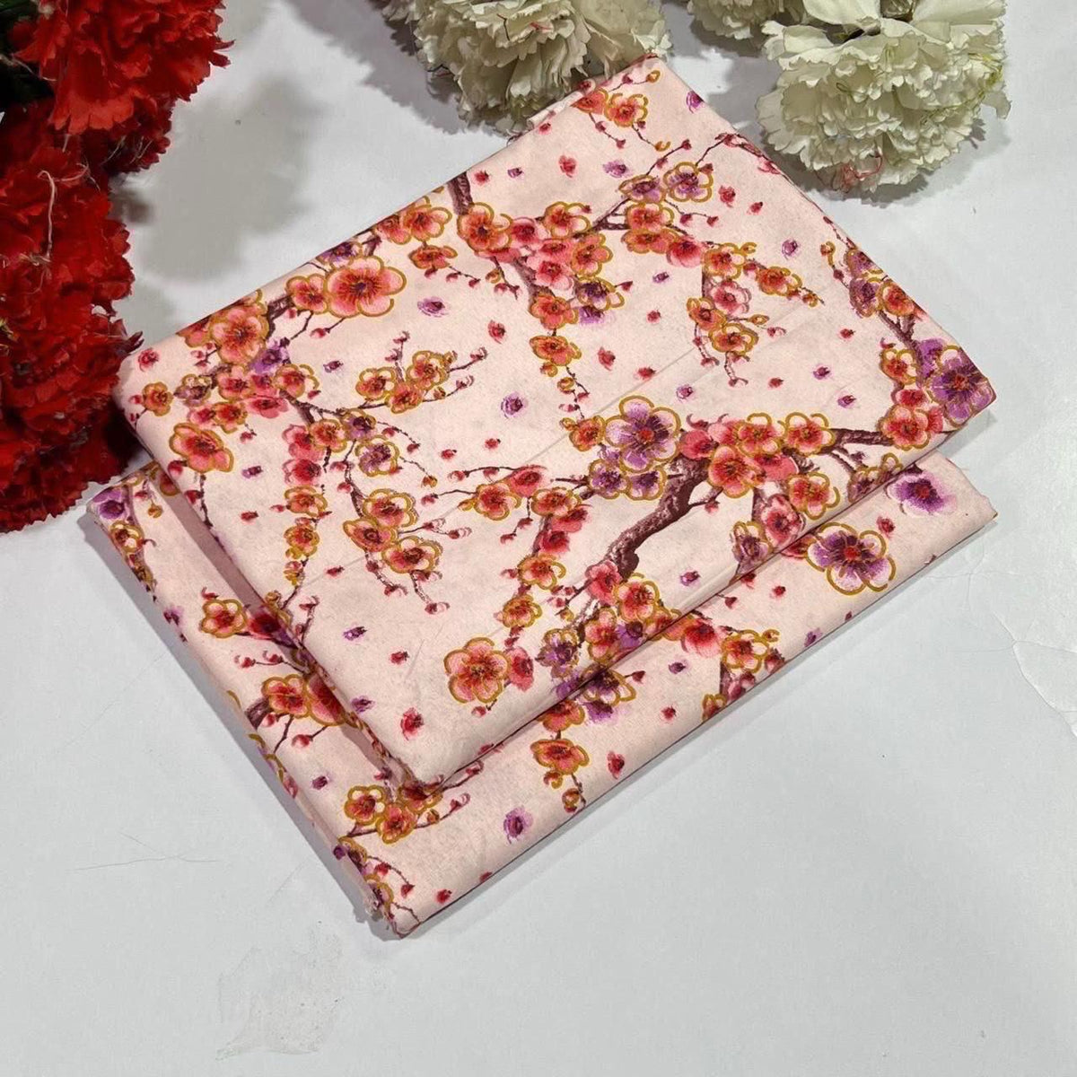 2 piece suit in light pink  with a cherry blossom branch pattern in red, orange