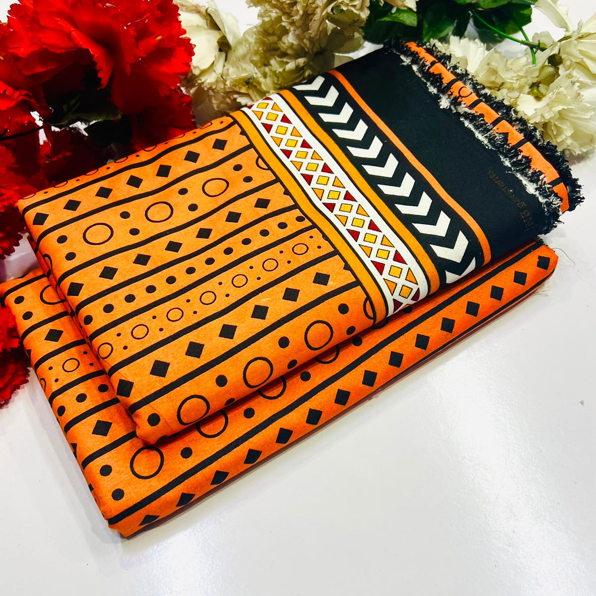 2 piece suit featuring a bold orange and black geometric pattern 