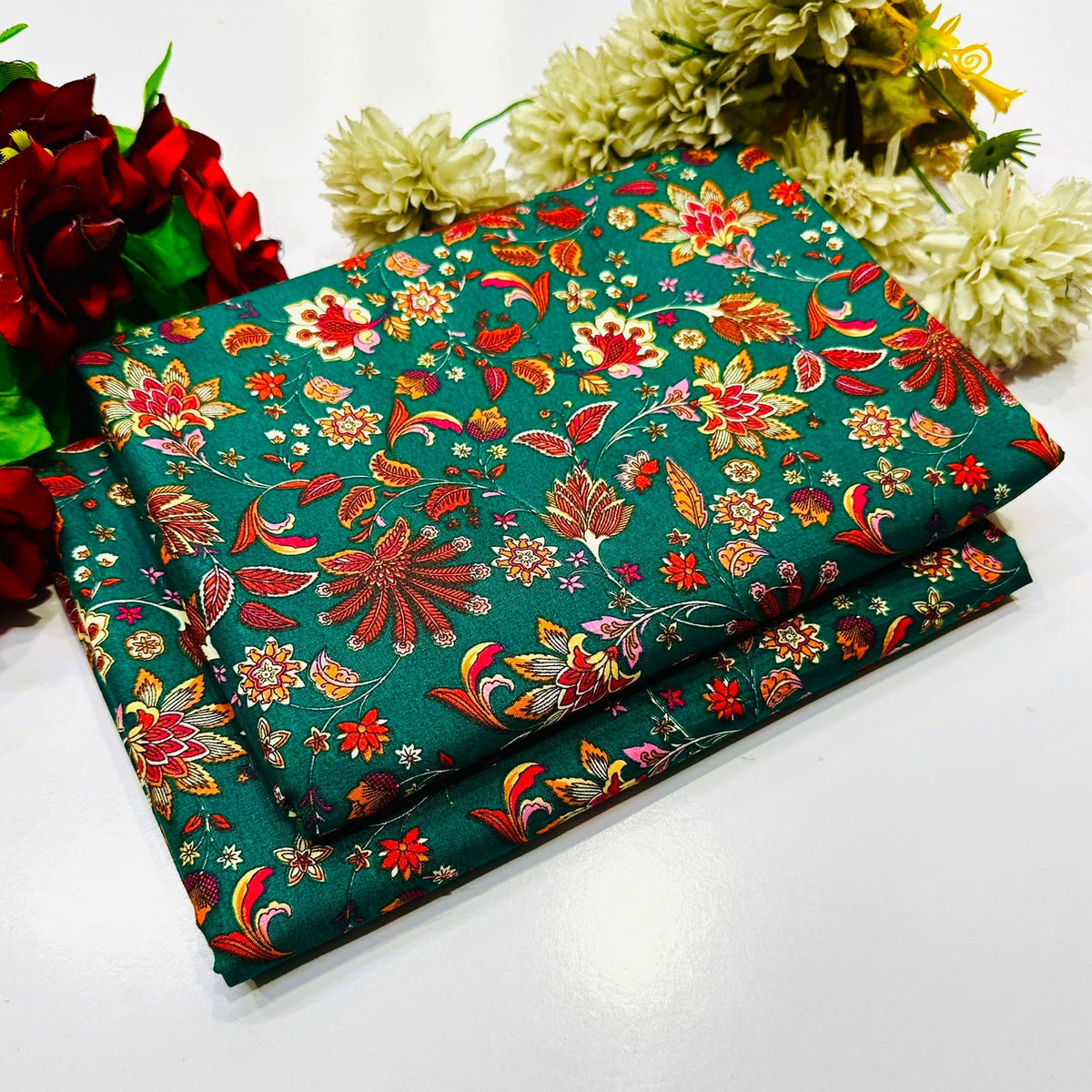 2 piece suit in dark teal green fabric with a vibrant, multicolored floral print